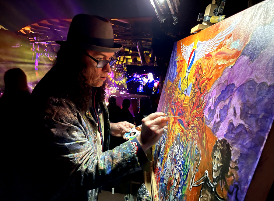 Artist painting vibrant canvas at live event
